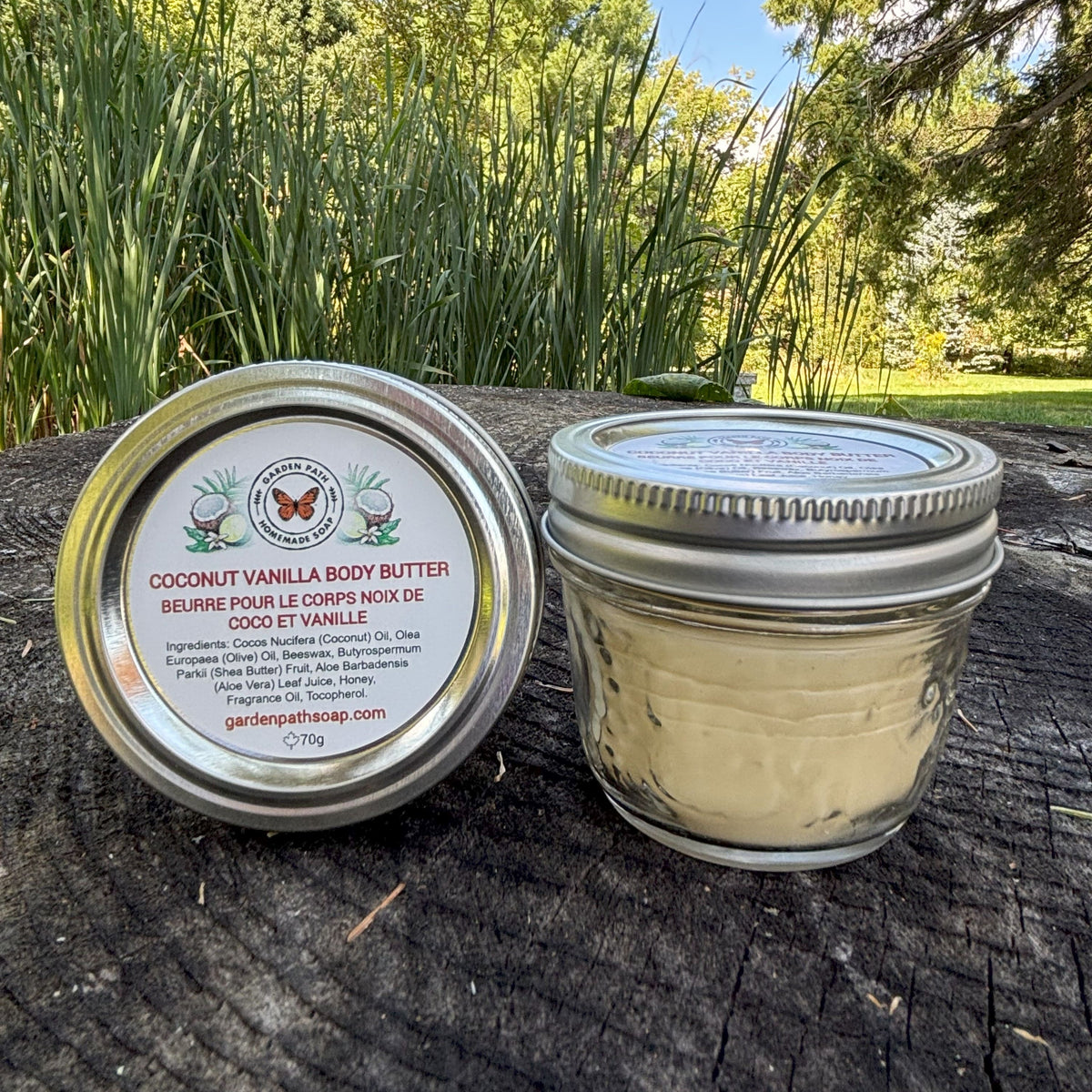 Jar of Coconut Vanilla Body Butter on a stump outdoor natural setting by Garden Path Homemade Soap
