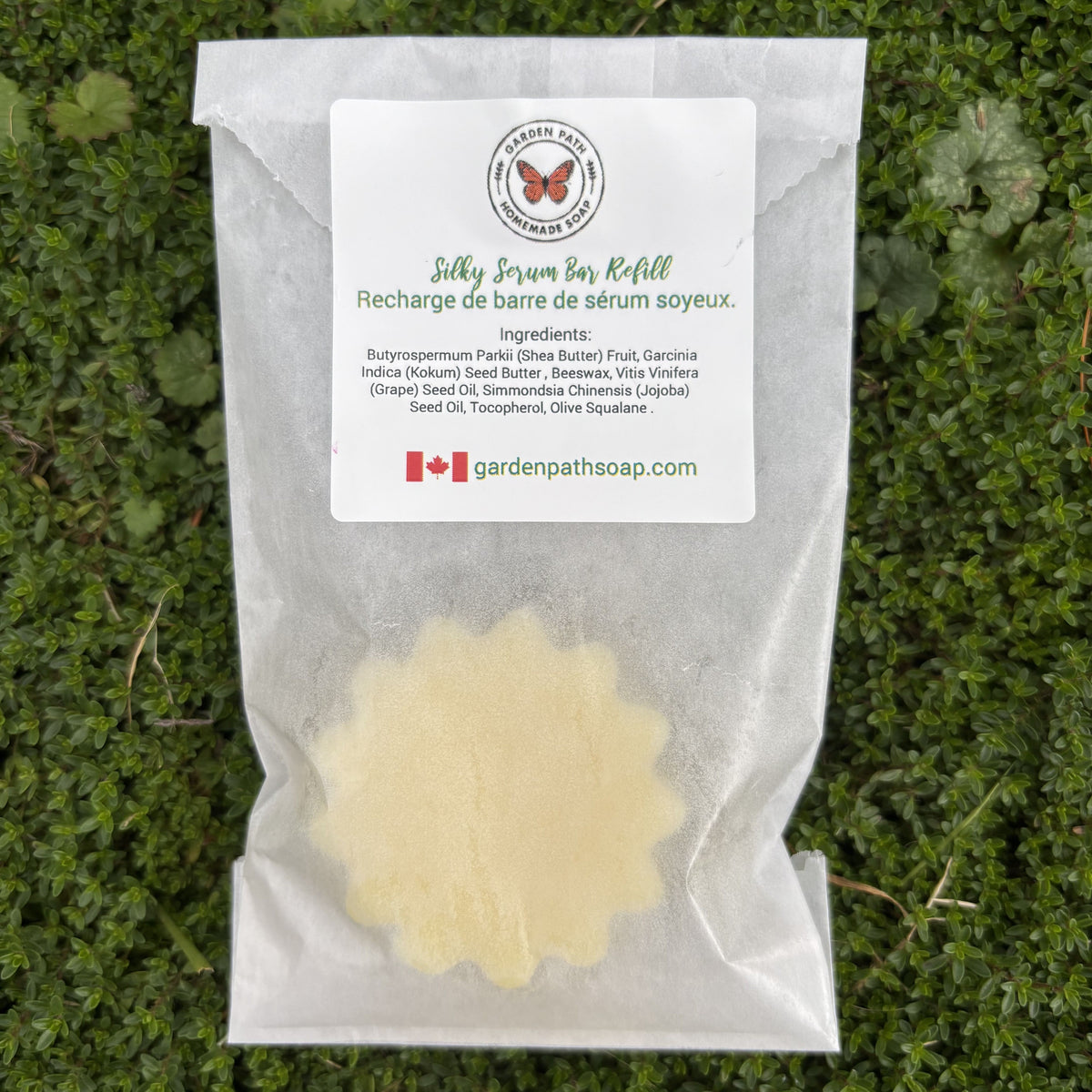Silky Serum Bar Refill packaging with a label on a grass background. Garden Path Homemade Soap - 100% Natural Ingredients