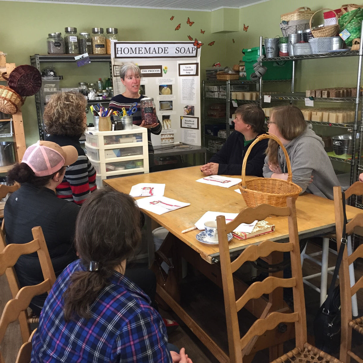 teacher explaining to a group of people how soap is made
