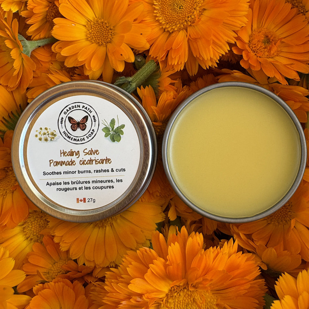 Healing salve in a tin surrounded by calendula flowers by Garden Path Homemade Soap. 100% Natural Ingredients & Essential Oils 