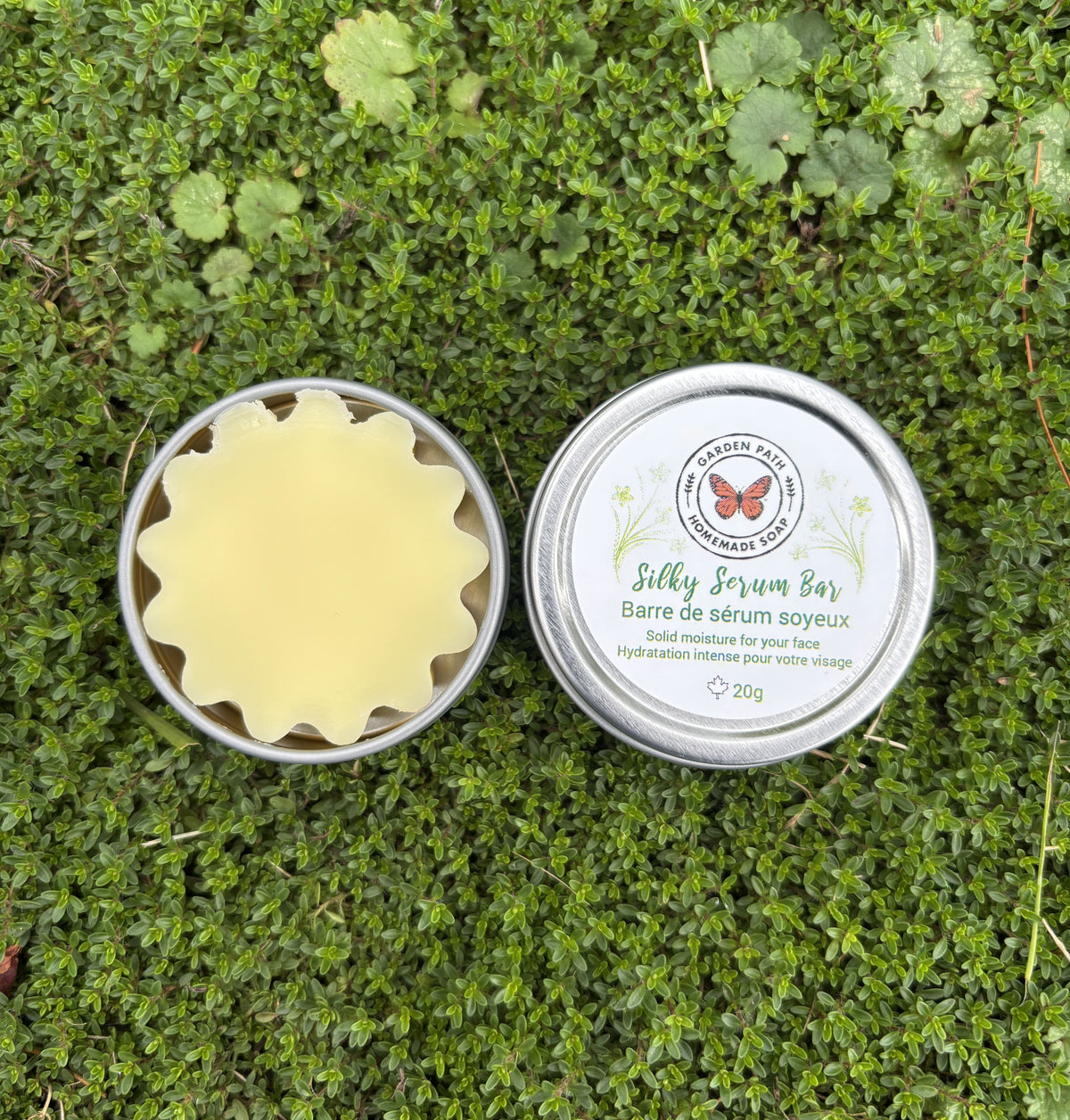 Silky Serum Bar in a metal container on green grass by Garden Path Homemade Soap .  100% Natural Ingredients