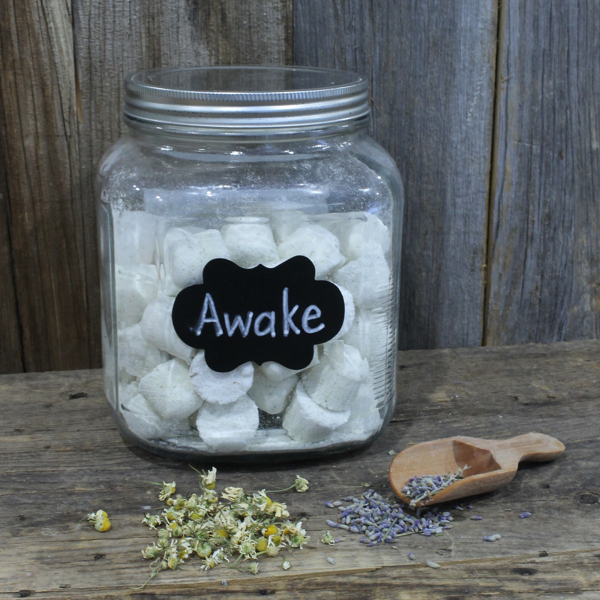 Jar of awake shower tablets with dried lavender and chamomile on a wooden surface by Garden Path Homemade Soap. 100% Natural Essential Oils | Aromatherapy