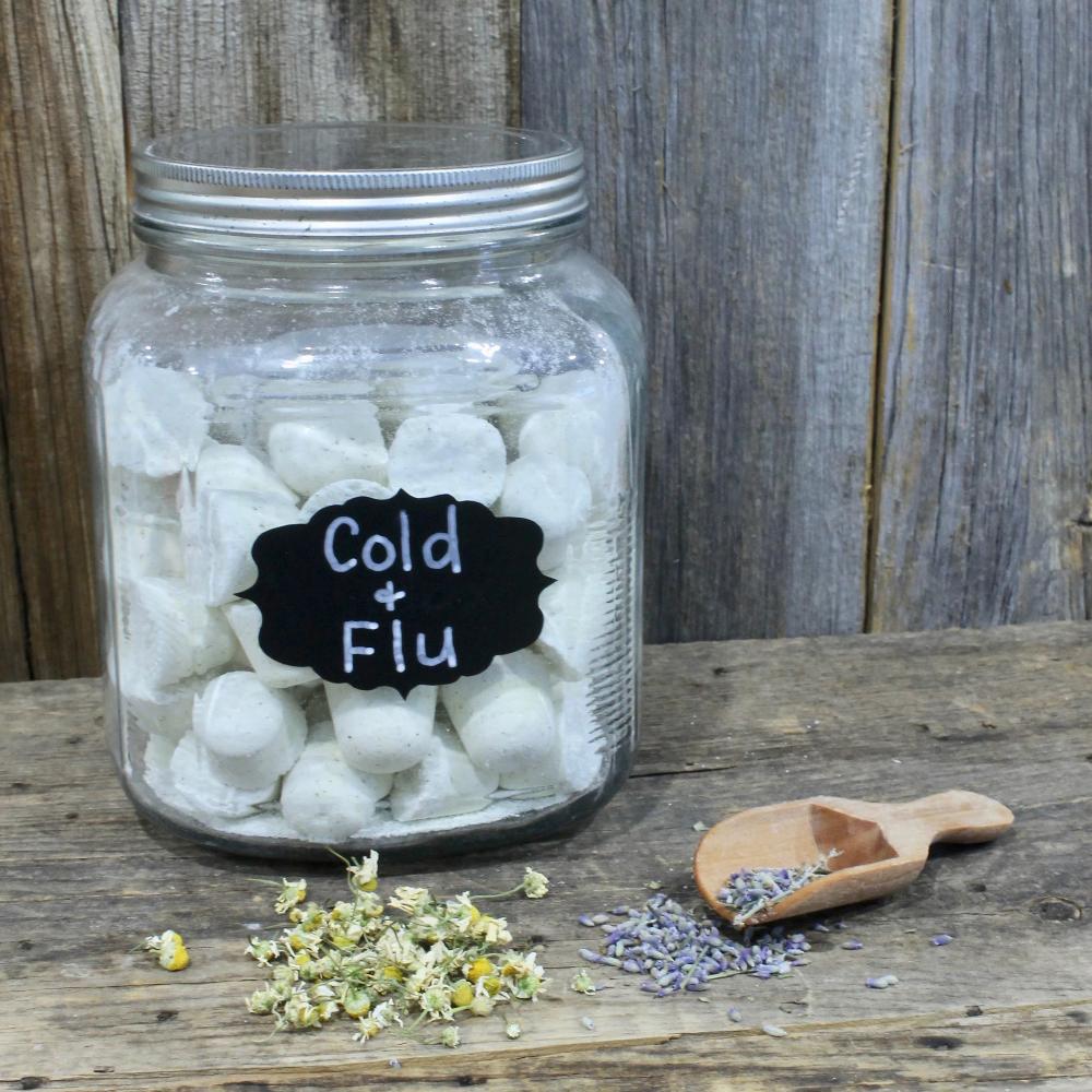 Jars filled with Cold & Flu shower tablets with dried lavender and chamomile on a wooden surface by Garden Path Homemade Soap. 100% Natural Essential Oils | Aromatherapy